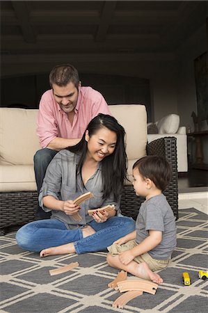 simsearch:6118-07966891,k - Smiling man and woman playing with their young son, building a wooden railway. Photographie de stock - Premium Libres de Droits, Code: 6118-08202573