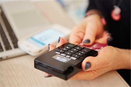 people with credit card - A woman's hands holding a credit card reader, processing payment or paying for goods. Stock Photo - Premium Royalty-Free, Code: 6118-08202523