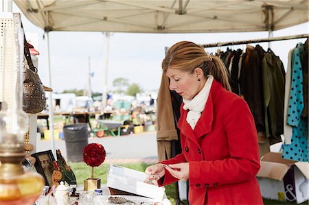 red scarf woman - A mature woman bargain hunter browsing through vintage jewellery items at a clothing stall at a flea market. Stock Photo - Premium Royalty-Free, Code: 6118-08202538