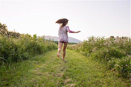 simsearch:6118-08220642,k - A woman running along a path in a meadow. Fotografie stock - Premium Royalty-Free, Codice: 6118-08220643