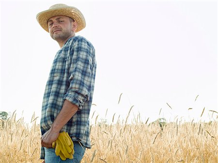 simsearch:6118-08220592,k - Man wearing a checked shirt and a hat standing in a cornfield. Stockbilder - Premium RF Lizenzfrei, Bildnummer: 6118-08220610