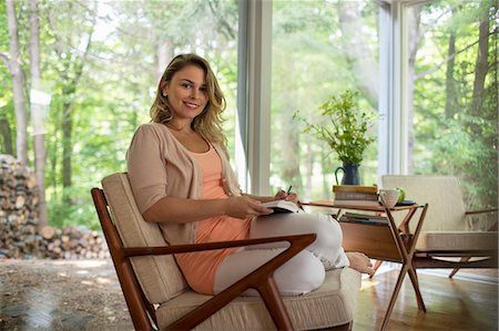 A woman seated holding an open journal and a pen. Foto de stock - Sin royalties Premium, Código: 6118-08226946