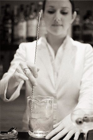 A young woman mixing a cocktail, a mixologist at work. Stock Photo - Premium Royalty-Free, Code: 6118-08226900