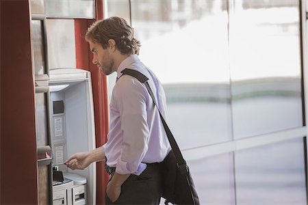 simsearch:6118-08351860,k - A man with a laptop bag using an ATM, a cash machine on a city street. Stock Photo - Premium Royalty-Free, Code: 6118-08351845