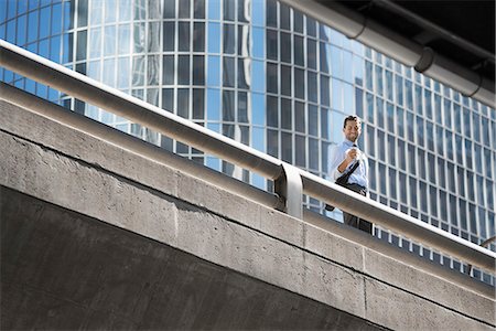 simsearch:6118-08351860,k - A man on an urban walkway taking a selfie with his mobile phone. Stock Photo - Premium Royalty-Free, Code: 6118-08351854