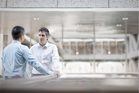 Two men, business colleagues, standing talking. Fotografie stock - Premium Royalty-Free, Codice: 6118-08351948