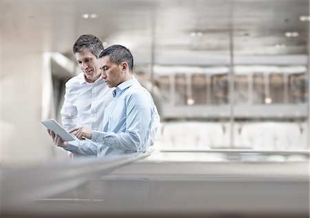 Two men, business colleagues, looking at a digital tablet screen. Stock Photo - Premium Royalty-Free, Code: 6118-08351949