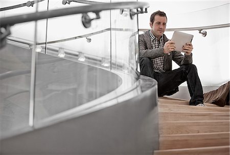 simsearch:6118-08351860,k - A man seated on steps using a digital tablet. Stock Photo - Premium Royalty-Free, Code: 6118-08351960