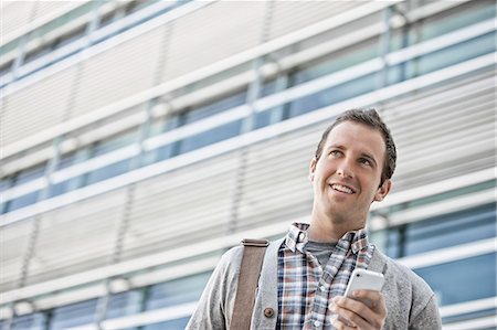 simsearch:6118-08351860,k - A man in a checked shirt with open collar holding his smart phone. Stock Photo - Premium Royalty-Free, Code: 6118-08351978