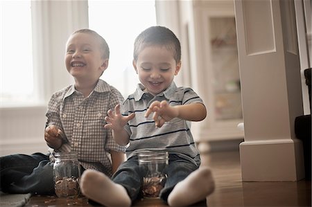 paniqué - Two children playing with coins, dropping them into glass jars. Foto de stock - Sin royalties Premium, Código: 6118-08351989