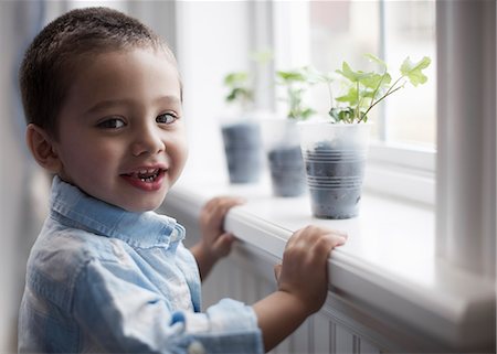 simsearch:6118-08660001,k - A young boy looking at young plants in pots growing on a windowsill. Stock Photo - Premium Royalty-Free, Code: 6118-08351995