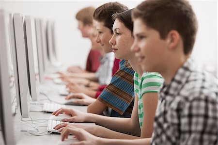 simsearch:6118-08351907,k - A group of young people, boys and girls, students in a computer class working at screens. Fotografie stock - Premium Royalty-Free, Codice: 6118-08351903