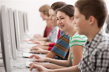 simsearch:6118-08351907,k - A group of young people, boys and girls, students in a computer class working at screens. Fotografie stock - Premium Royalty-Free, Codice: 6118-08351904