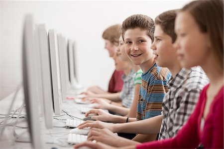 simsearch:6118-08351907,k - A group of young people, boys and girls, students in a computer class working at screens. Fotografie stock - Premium Royalty-Free, Codice: 6118-08351905