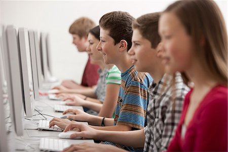 simsearch:6118-08351907,k - A group of young people, boys and girls, students in a computer class working at screens. Fotografie stock - Premium Royalty-Free, Codice: 6118-08351908