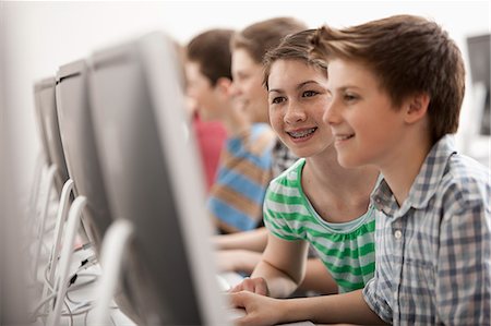 simsearch:6118-08351907,k - A group of young people, boys and girls, working at computer screens in class. Photographie de stock - Premium Libres de Droits, Code: 6118-08351912