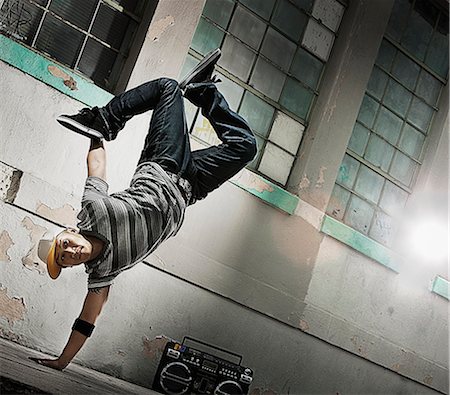 stereo - A young man breakdancing on the street of a city, doing a one handed handstand. Photographie de stock - Premium Libres de Droits, Code: 6118-08393897