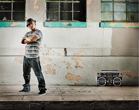 A young man, a breakdancer performer with a boombox on the street of a city. Photographie de stock - Premium Libres de Droits, Code: 6118-08393898