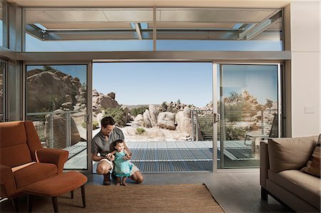 simsearch:6118-08827464,k - A man and a young child in an ecohouse, a home with large glass walls and view out over the rocky landscape. Stockbilder - Premium RF Lizenzfrei, Bildnummer: 6118-08393989