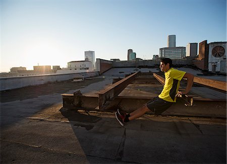simsearch:6118-08394085,k - A man in exercise clothes on a rooftop overlooking the city, doing bench shoulder push ups. Foto de stock - Sin royalties Premium, Código: 6118-08394096