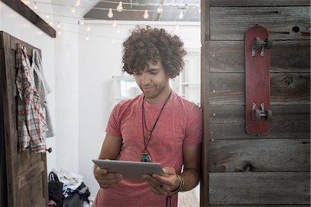 simsearch:851-02964178,k - Loft living. A young man standing looking at a digital tablet. Foto de stock - Sin royalties Premium, Código: 6118-08394028