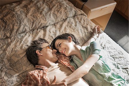 A young couple lying side by side on top of the bed in a motel room. Stockbilder - Premium RF Lizenzfrei, Bildnummer: 6118-08394188