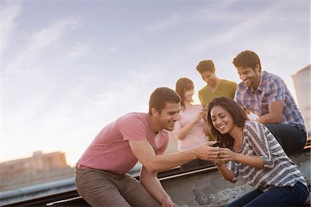 simsearch:6118-08394082,k - A group of men and women on a rooftop terrace having a party. Foto de stock - Sin royalties Premium, Código: 6118-08394101