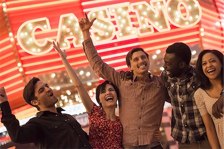 A group of people under a bright neon Casino sign. Stock Photo - Premium Royalty-Free, Code: 6118-08394209