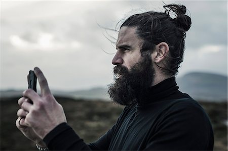 scottish island - A man taking a photograph with a smart phone. Stock Photo - Premium Royalty-Free, Code: 6118-08399694