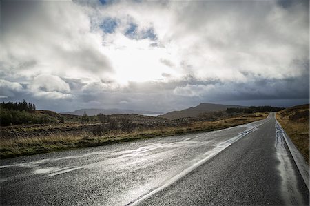 An empty two lane road through a deserted landscape, reaching into the distance. Low cloud in the sky. Photographie de stock - Premium Libres de Droits, Code: 6118-08399715