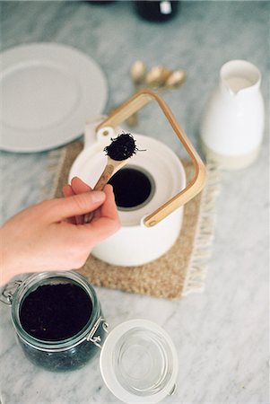 simsearch:670-03709960,k - High angle view of a tea pot and a glass jar with tea leaves, woman preparing tea. Foto de stock - Sin royalties Premium, Código: 6118-08313741