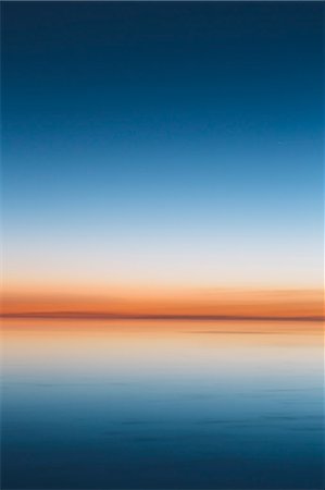 The view to the clear line of the horizon where land meets sky, across the flooded surface of Bonneville Salt Flats. Dawn light, Stock Photo - Premium Royalty-Free, Code: 6118-08313773