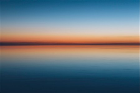 The view to the clear line of the horizon where land meets sky, across the flooded surface of Bonneville Salt Flats. Dawn light, Stock Photo - Premium Royalty-Free, Code: 6118-08313772