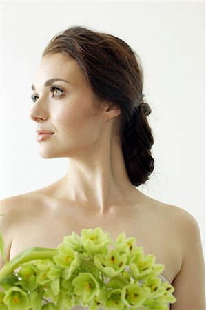 earrings woman portrait photography - Portrait of a woman with brown hair tied in an elegant bun, wearing a dress with a green flower wreath. Stock Photo - Premium Royalty-Free, Code: 6118-08313735