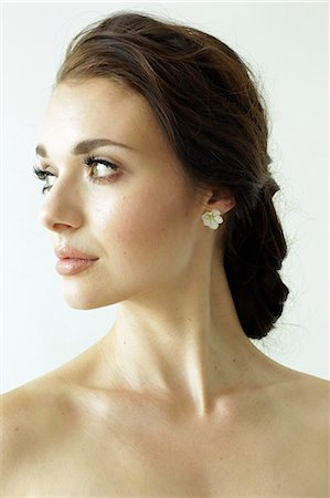 earrings woman portrait photography - Portrait of a woman with brown hair tied in an elegant bun. Stock Photo - Premium Royalty-Free, Code: 6118-08313736