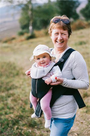 england girl image - A woman carrying a baby in a baby carrier, outdoors. Stock Photo - Premium Royalty-Free, Code: 6118-08313816
