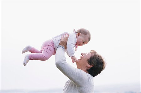 senior playing with kids - A woman holding a baby girl in the air above her head. Foto de stock - Sin royalties Premium, Código: 6118-08313821