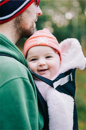 A baby in a sling being carried by her father, outdoors in winter. Stock Photo - Premium Royalty-Free, Code: 6118-08313836