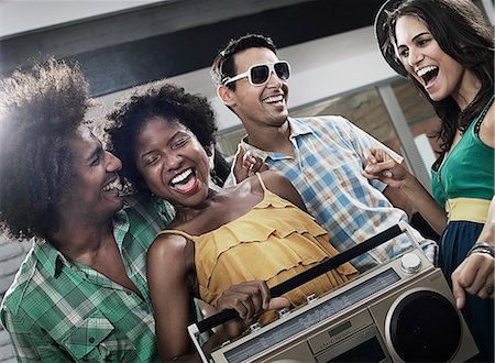 simsearch:6118-07966892,k - Four friends with a large portable music player, having a party. Stock Photo - Premium Royalty-Free, Code: 6118-08488219