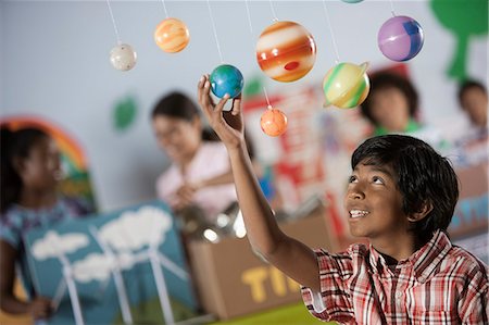 A boy looking up at a display of the planets, a presentation of the planetary system. Stock Photo - Premium Royalty-Free, Code: 6118-08488227