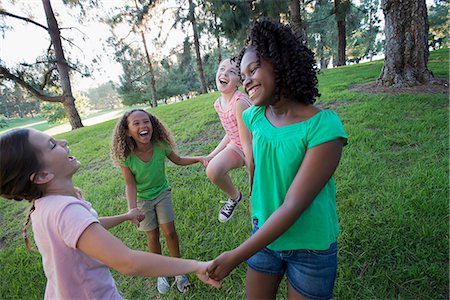 simsearch:6118-07913333,k - A group of four girls holding hands and dancing outside. Stock Photo - Premium Royalty-Free, Code: 6118-08488344