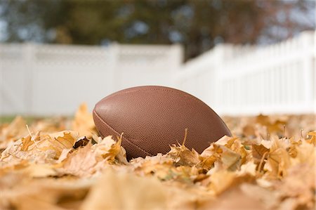An oval football on the ground among autumn leaves. Stock Photo - Premium Royalty-Free, Code: 6118-08488372