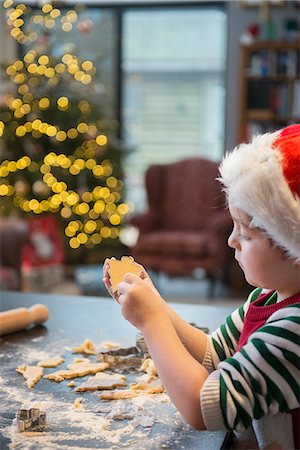 simsearch:6118-08660132,k - A boy in a Santa hat making Christmas biscuits, cutting out shapes. Stock Photo - Premium Royalty-Free, Code: 6118-08488469