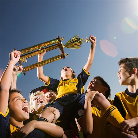 A group of boys in soccer team shirts holding a trophy and celebrating a win. Stockbilder - Premium RF Lizenzfrei, Bildnummer: 6118-08521676