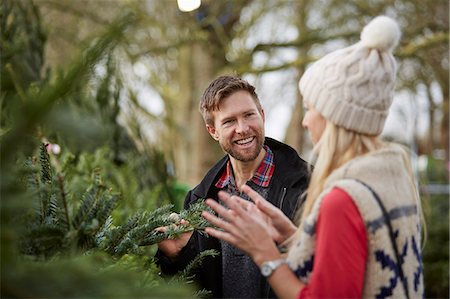 plant nursery - A man and woman discussing and choosing a traditional pine tree, Christmas tree. Stock Photo - Premium Royalty-Free, Code: 6118-08521693