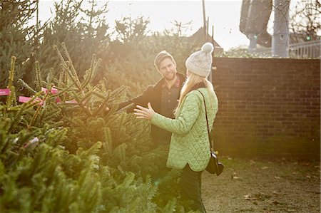 A man and woman choosing a traditional pine tree, Christmas tree from a large selection at a garden centre. Stock Photo - Premium Royalty-Free, Code: 6118-08521690