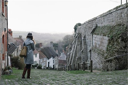 A woman at the top of Gold Hill, a steep cobbled street in Shaftesbury. Stock Photo - Premium Royalty-Free, Code: 6118-08521772