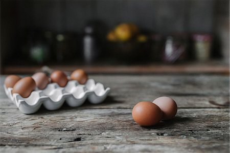 simsearch:6118-08521776,k - Fresh hen's eggs in a box and on a wooden table. Photographie de stock - Premium Libres de Droits, Code: 6118-08521775
