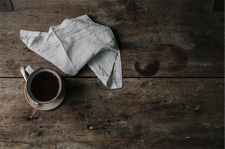 A cup of coffee and a napkin on a table. Stock Photo - Premium Royalty-Free, Code: 6118-08521785