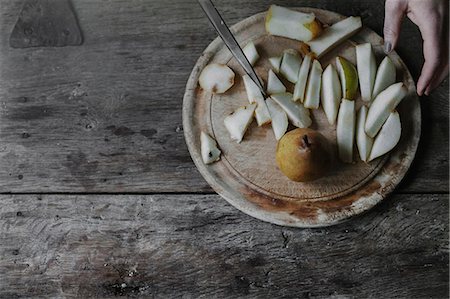 simsearch:6118-08521776,k - A woman slicing fresh fruit, pears on a chopping board. Photographie de stock - Premium Libres de Droits, Code: 6118-08521788